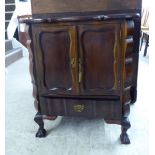 A 20thC mahogany finished bedside cupboard with a pair of doors and a single drawers,
