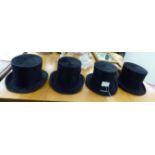 Four similar black silk top hats various sizes CA