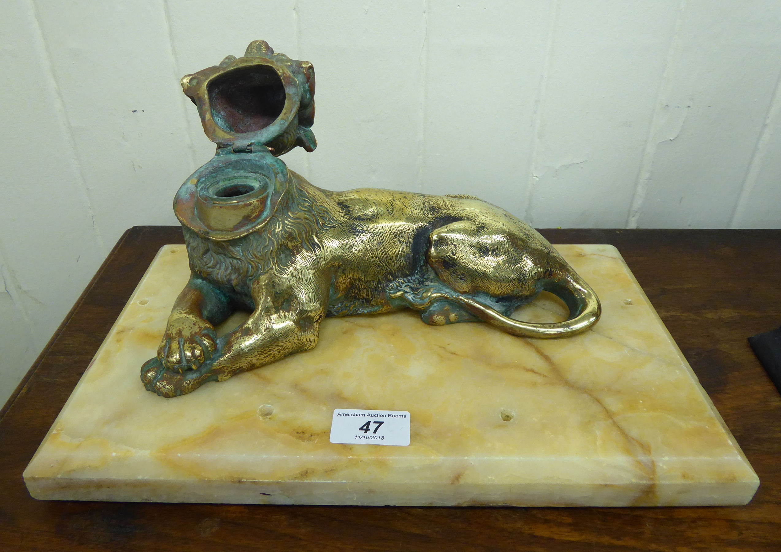 An early 20thC lacquered brass inkwell, fashioned as a seated lioness, - Image 2 of 2