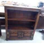 A modern reproduction of an Old English style, stained oak bookcase with two open shelves,