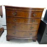 A modern mahogany four drawer bow front dressing chest with a brushing slide,