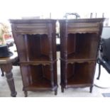 A pair of early 20thC mahogany corner cabinets with two open shelves,
