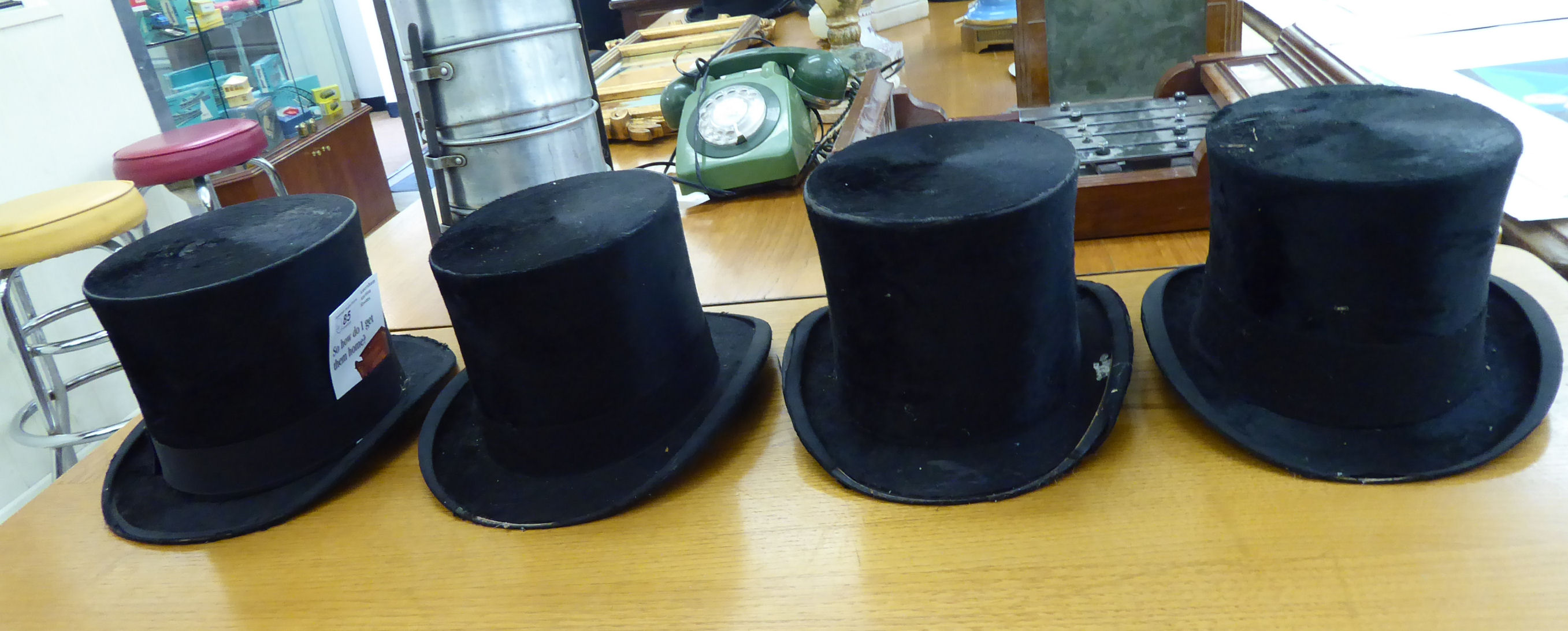 Four similar black silk top hats various sizes CA