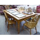 A modern farmhouse style chestnut dining table, the top with round corners, over six frieze drawers,