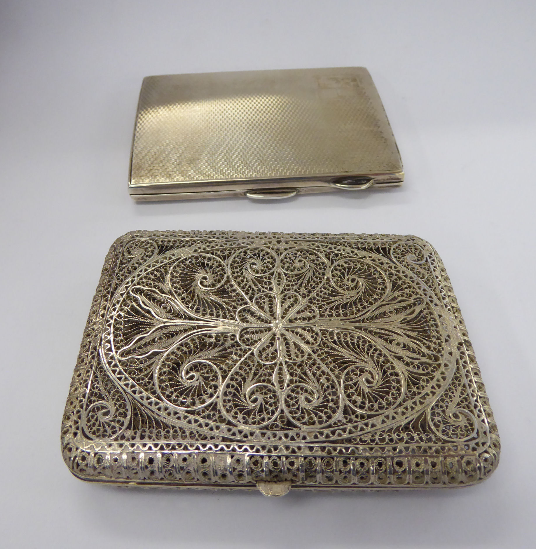 A white metal filigree cigarette case;