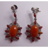 A pair of coral and diamond set pendant earrings