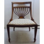 An Edwardian satinwood inlaid mahogany framed salon chair with a fan shaped back splat and an