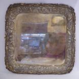 A silver coloured metal tray with a raised, cast and chased C-scrolled, shell,