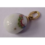 A Russian gold and enamelled egg pendant, having a white ground,
