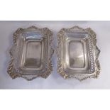 A pair of Edwardian silver shallow baskets with ornately cast, pierced C-scrolled,