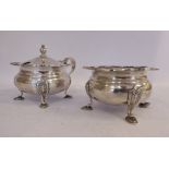 A silver lidded mustard pot with a loop handle and a wavy border,