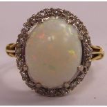 An 18ct gold claw set opal and diamond cluster ring
