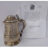 A George II silver lidded tankard of baluster form with a hinged, domed cover,