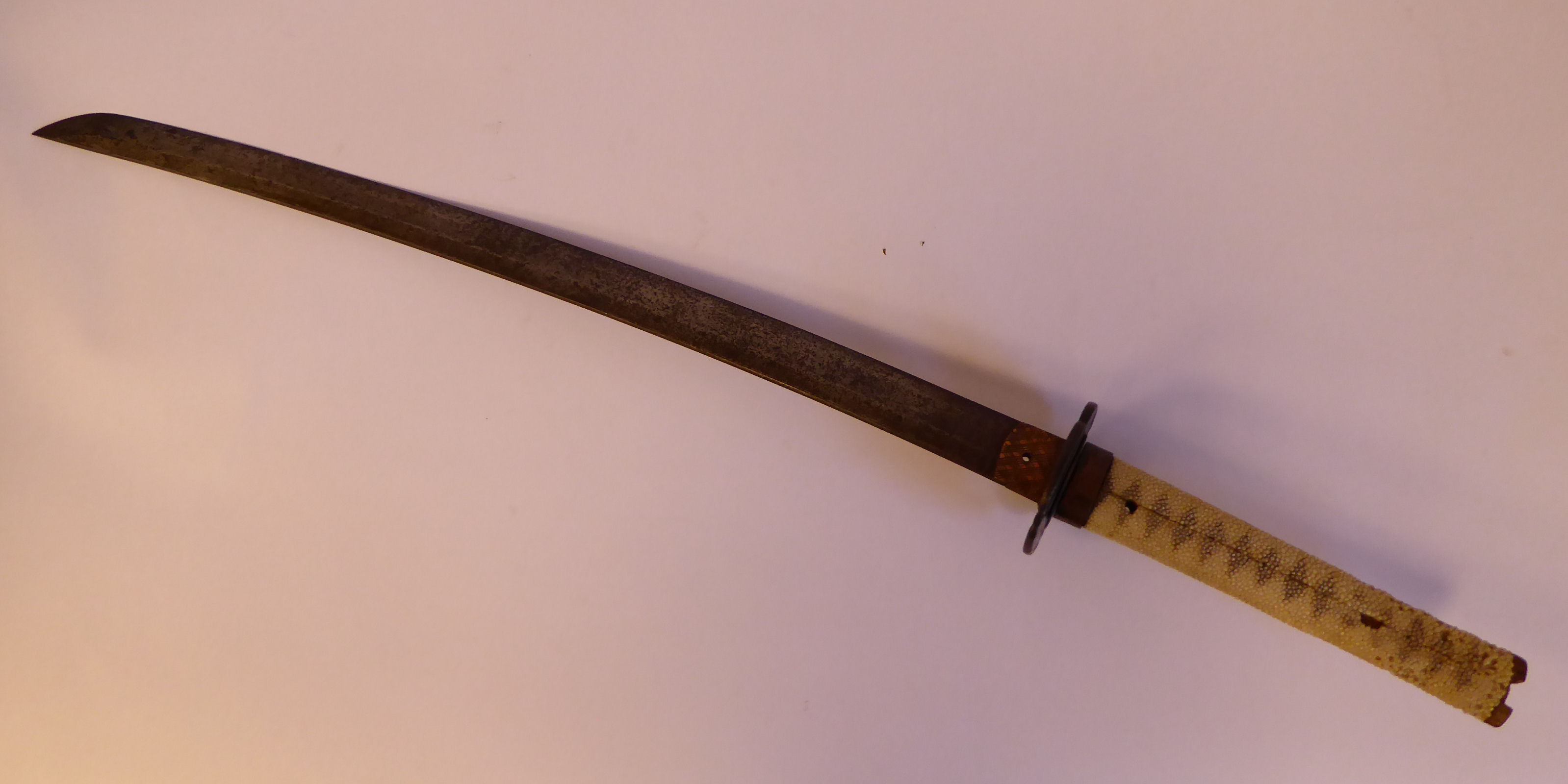 A mid 19thC Samurai sword with a shagreen bound handle and cast bronze tsuba the blade 21''L