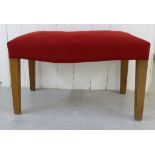 A mid 20thC TH Robsjohn-Gibbings stool, the red fabric upholstered cushioned seat raised on square,