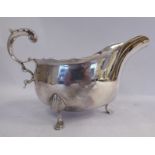A late Victorian/early Edwardian silver sauce boat with a C-scrolled handle and a wavy border,