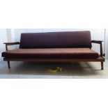 A Guy Rogers teak framed three person settee, the textured, covered brown/red fabric,