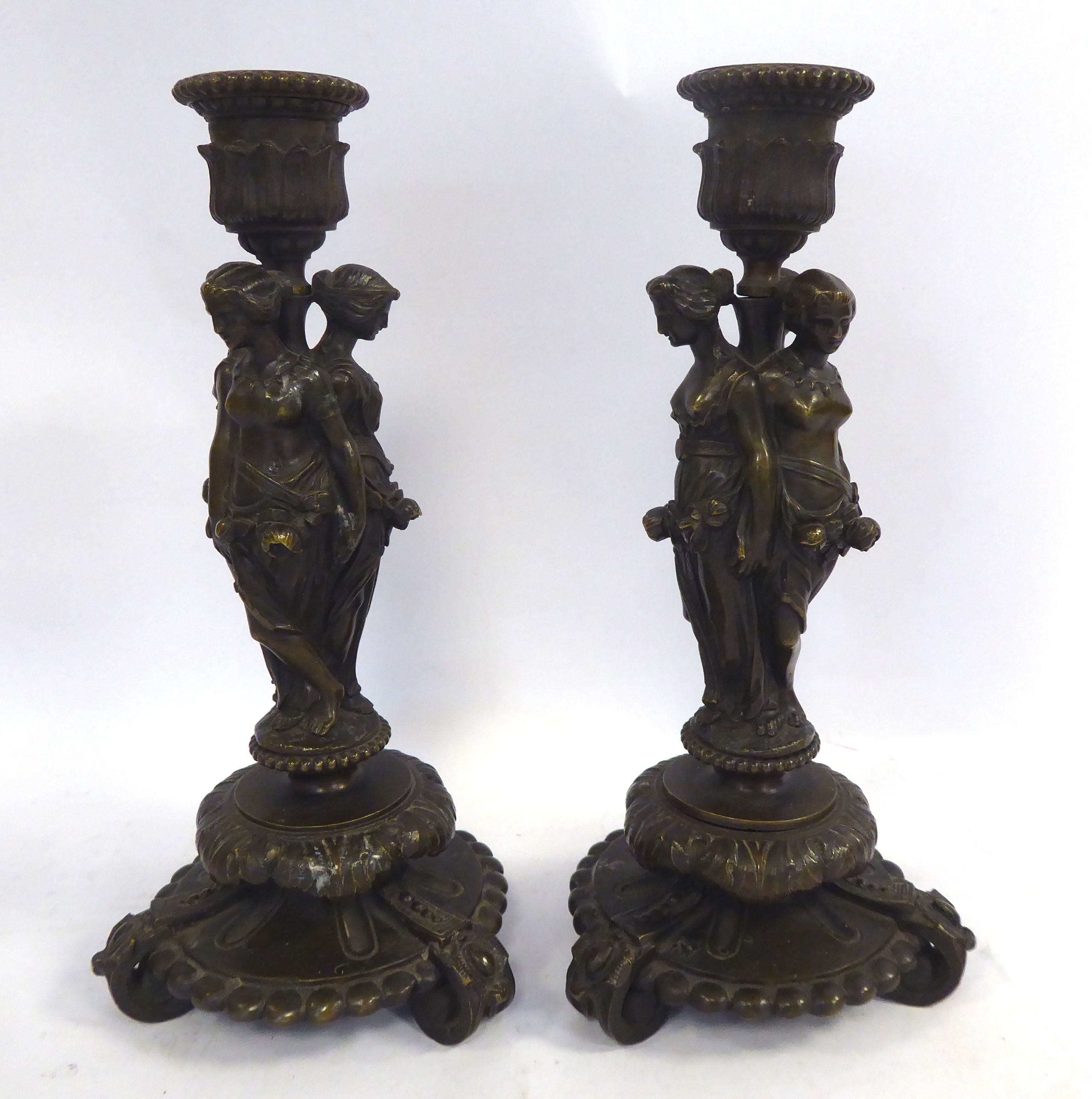 A pair of classically inspired cast and patinated bronze candlesticks,