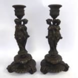 A pair of classically inspired cast and patinated bronze candlesticks,