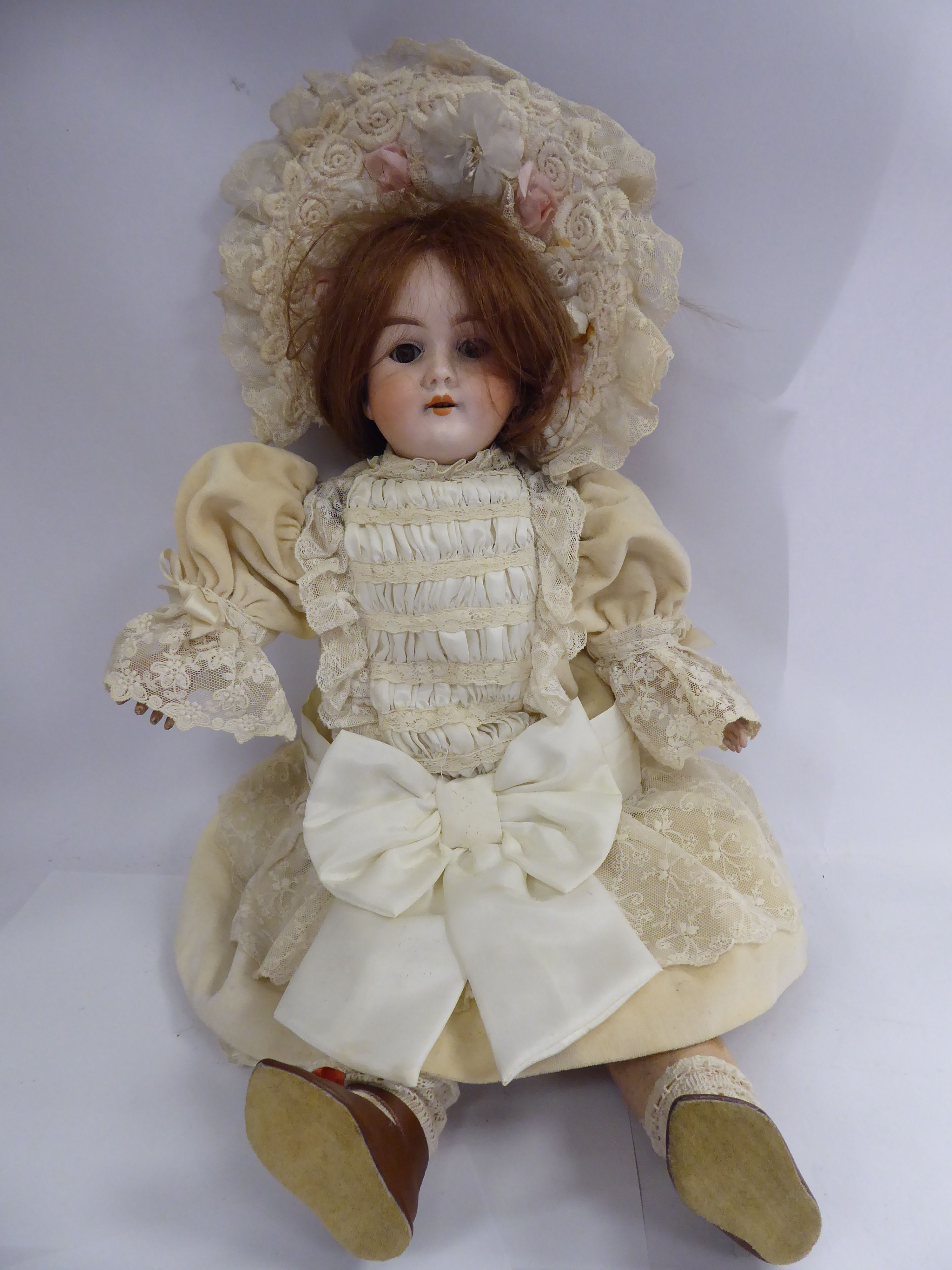 A Max Handwerck porcelain head doll with painted features and weighted, sleeping eyes,