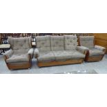 An Ercol light elm framed three piece wingback suite comprising a three person settee and two