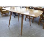 An Ercol light elm drop leaf dining table, raised on splayed, square,