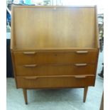 A 1980s Danish teak bureau with a fall flap, enclosing a part fitted interior, over three drawers,