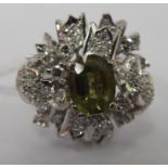 An 18ct white gold ring, set with a central green sapphire,