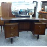 A 1960s/70s G-Plan mahogany dressing table with a mirror, over four drawers,