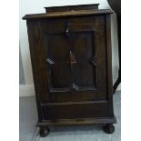 A 1920s stained oak purdonium with a panelled fall flap,