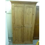 A modern pine wardrobe with a moulded cornice, a pair of panelled doors,