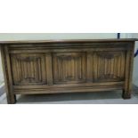 A mid 20thC oak chest with a tri-panelled linenfold front and a hinged lid,