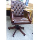 A modern Georgian style part button and stud upholstered brown open arm desk chair,