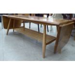 An Ercol light elm coffee table, the top with fall flaps, raised on turned,