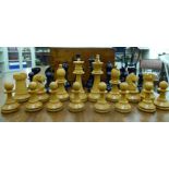 A set of early 20thC turned and stained wooden chess pieces,