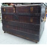 An early 20thC camphorwood oak and riveted iron bound trunk with straight sides and a domed lid,