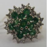 An 18ct gold emerald and diamond cluster ring 11