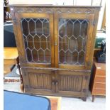 A modern stained oak Old English style bookcase with a pair of glazed doors,