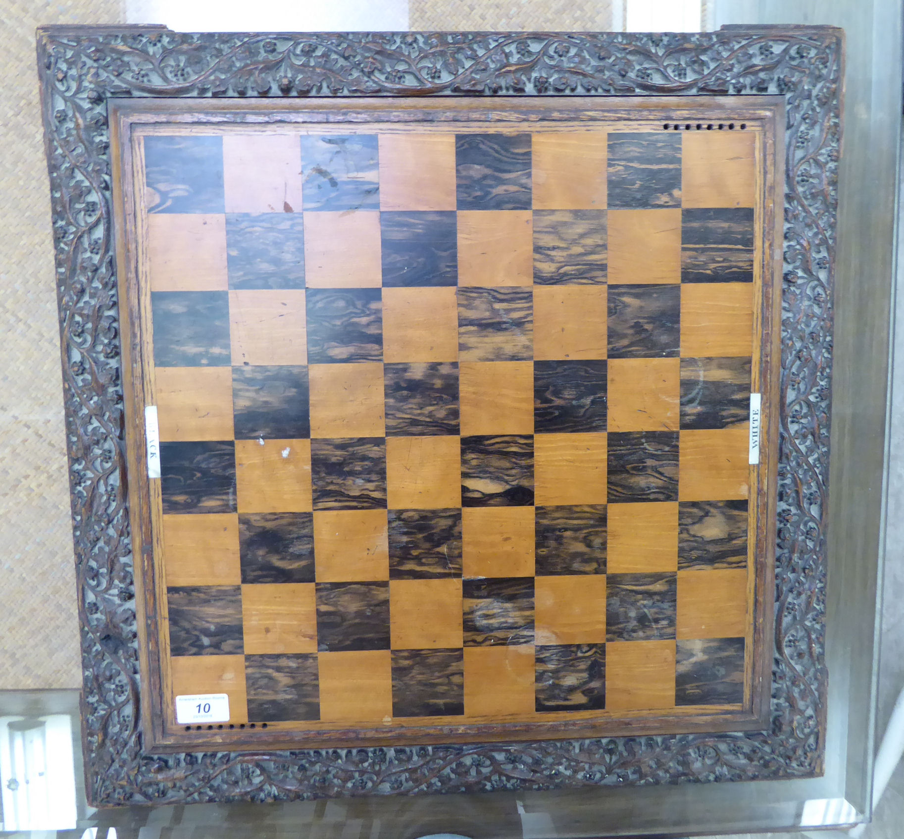 An early 20thC profusely foliate carved oak chess board,