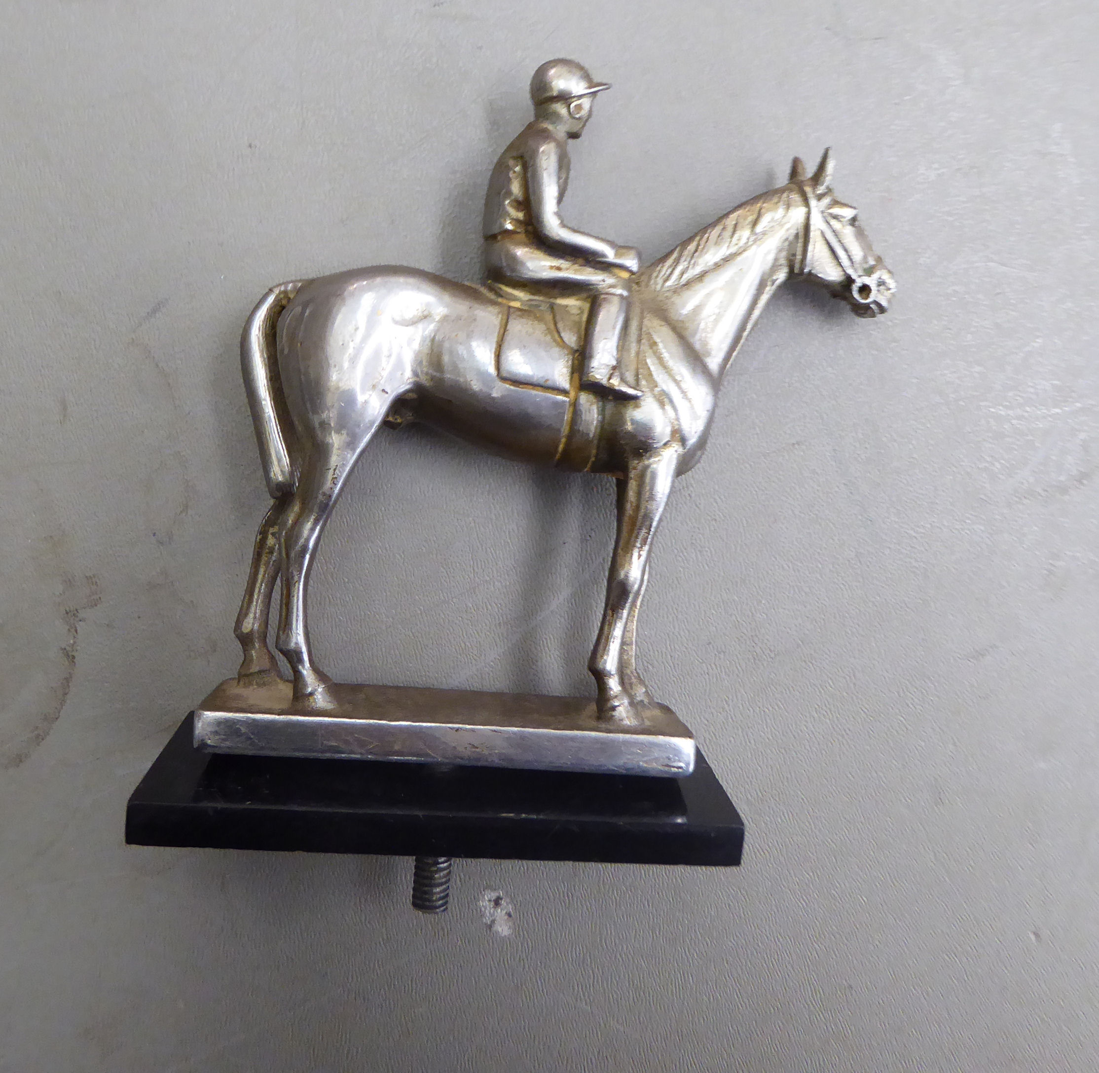 An early/mid 20thC silver plated steel car mascot, fashioned as a standing horse and jockey,
