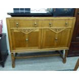 A mid 20thC light oak sideboard, the top with a low galleried upstand,