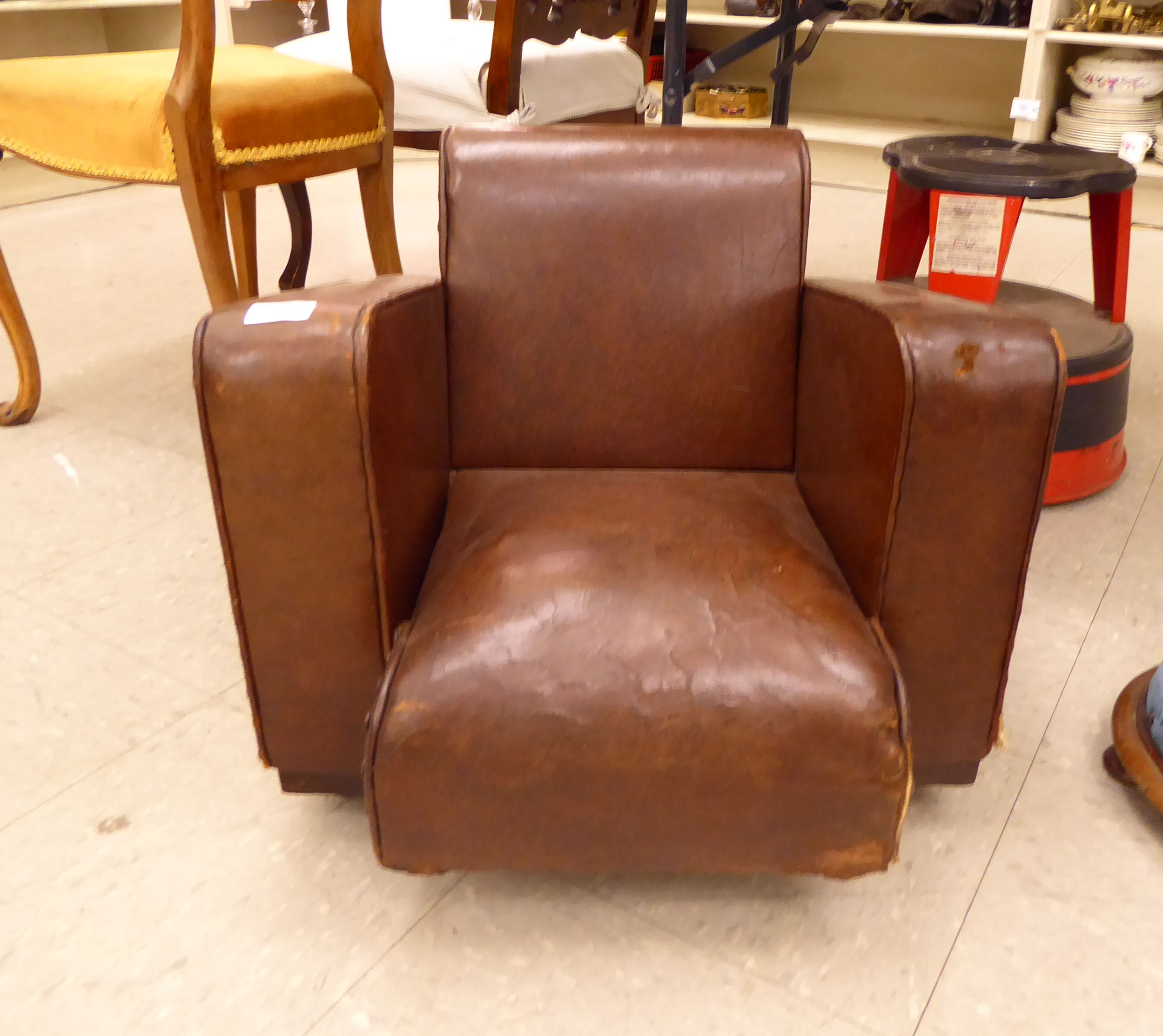 A mid 20thC child's stud upholstered brown faux hide armchair,