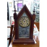 A late 19thC Ansonia Co stained beech cased mantel clock of pointed arch form with finials,