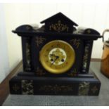 A 1930s black slate cased mantel clock of architectural form;