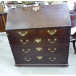 An early 19thC stained oak bureau, the fall-flap over two short/three long drawers,