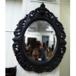A late Victorian oval bevelled mirror,