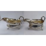 A pair of silver sauce boats with flared, gadrooned rims and double C-scrolled,