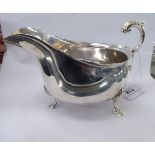 A late Victorian/early Edwardian silver sauce boat with a C-scrolled handle and a wavy border,