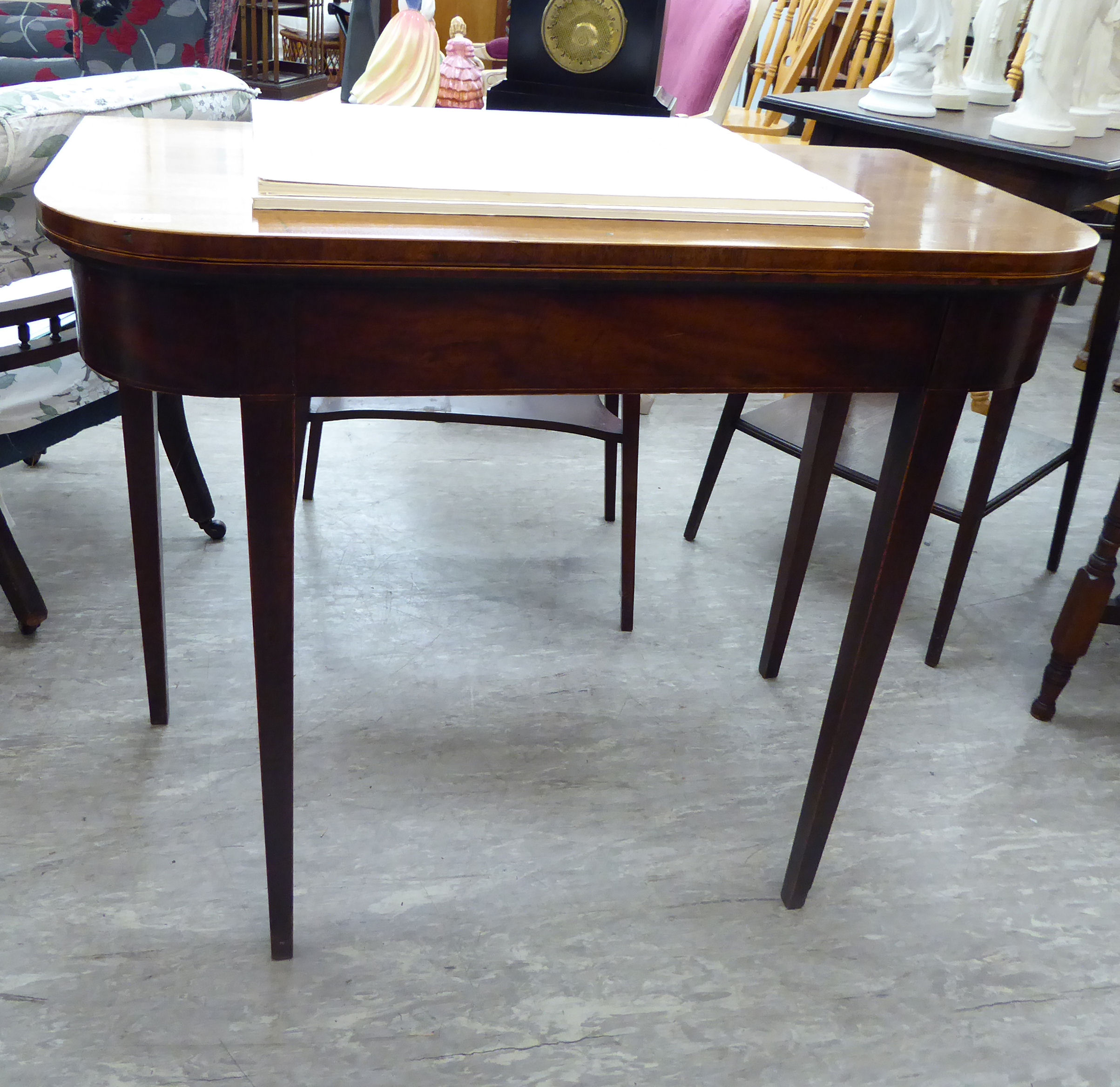 A George III string inlaid mahogany tea table, the foldover top raised on square,