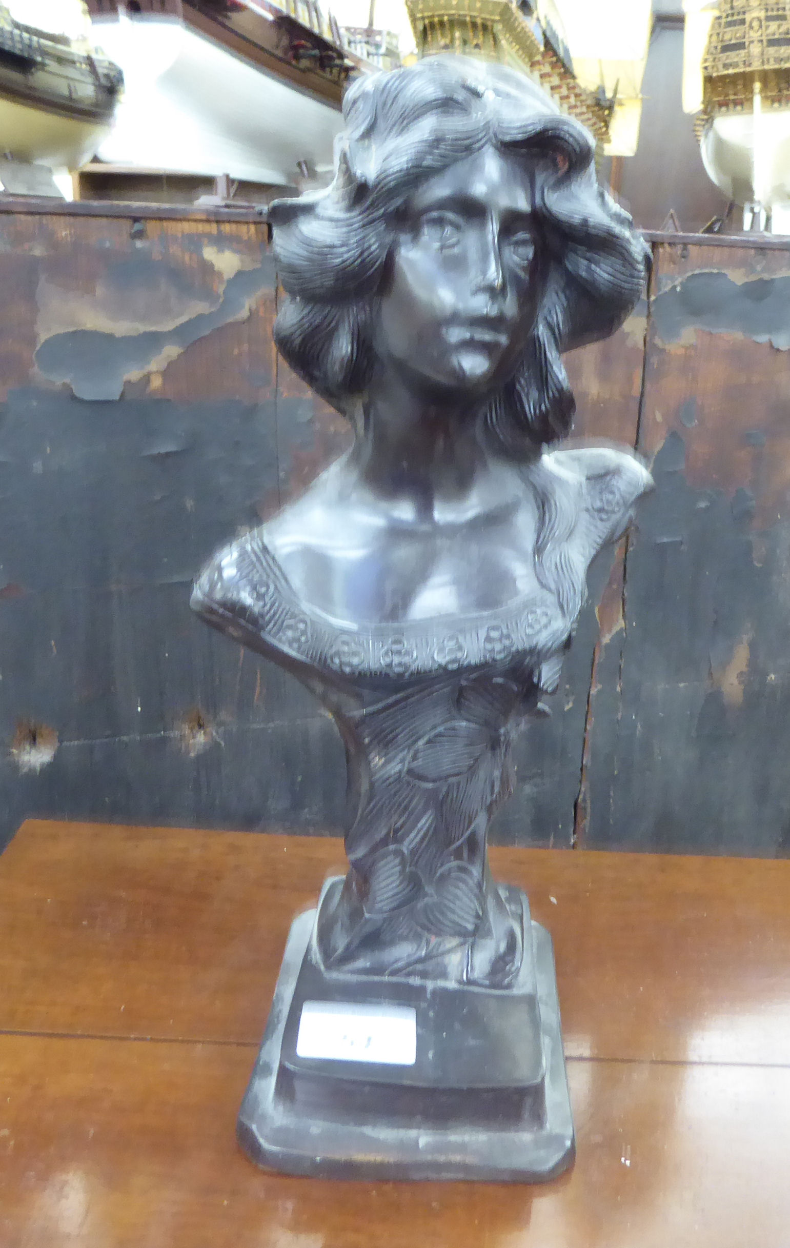 A 20thC cast and patinated bronze bust, on a stepped,